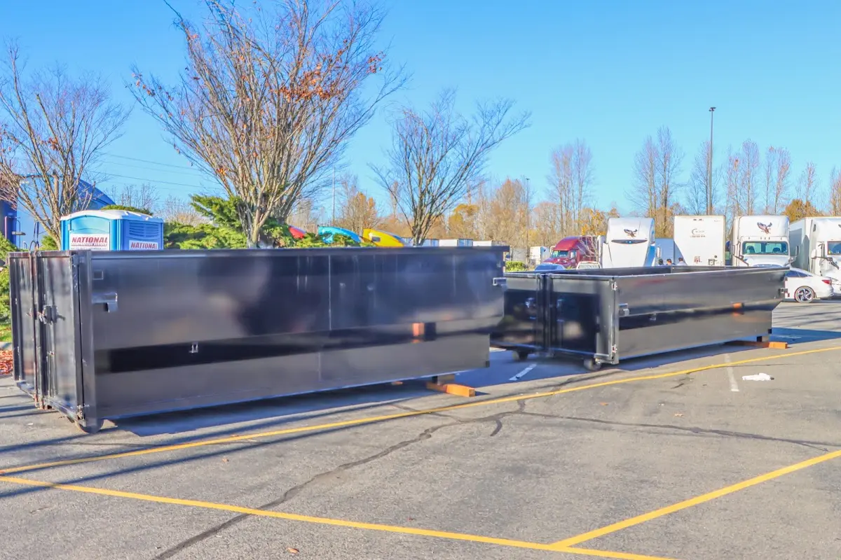 Professional dumpster rental service with roll-off container on residential driveway in Antrim